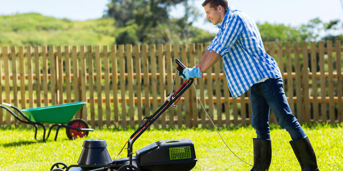 muž pečuje o trávník